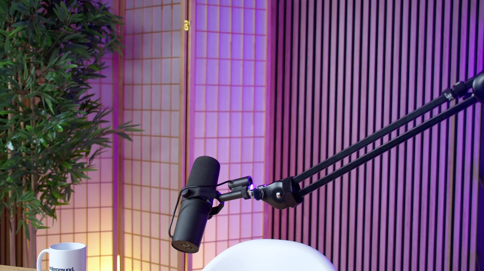 Studio podcast Underground Production avec micro sur bras articulé et décor coloré